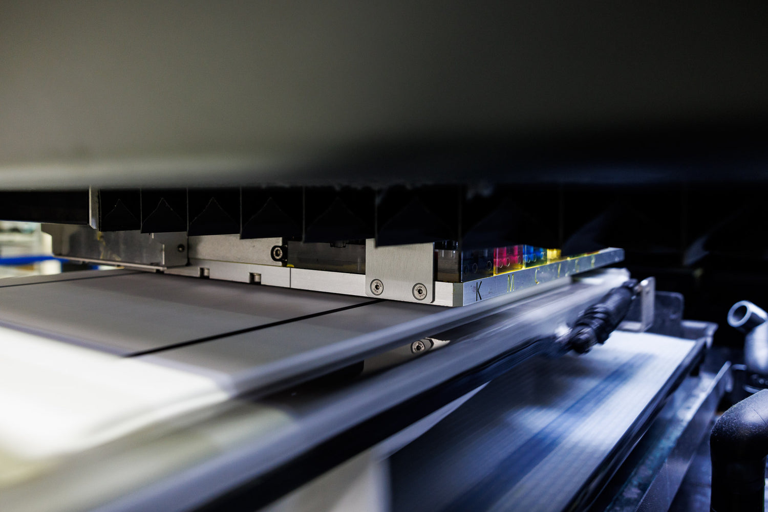 Close-up of a printing machine in action with ink cartridges.