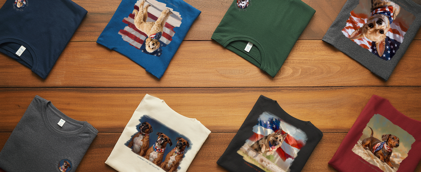 Collection of t-shirts with various designs from our "We the Dogs" collection on a wooden surface